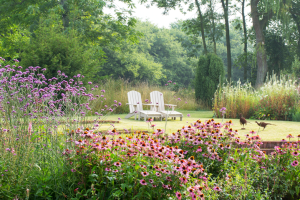Manor garden with pink flowers and two chairs